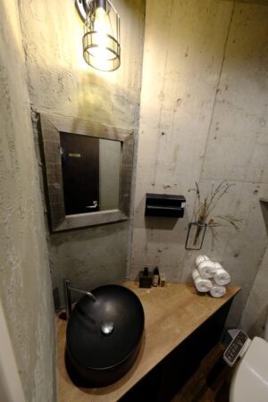 打ちっぱなしコンクリートの中にあたたかさを、木とグリーンで魅せる【Bistro 碧い月】