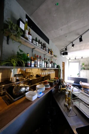 打ちっぱなしコンクリートの中にあたたかさを、木とグリーンで魅せる【Bistro 碧い月】