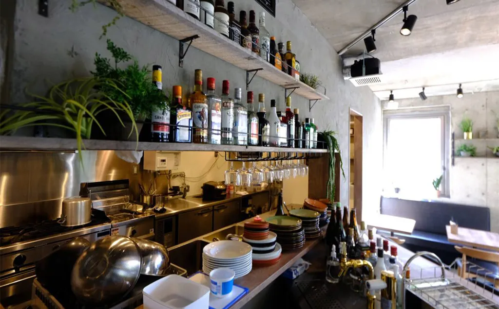 打ちっぱなしコンクリートの中にあたたかさを、木とグリーンで魅せる【Bistro 碧い月】