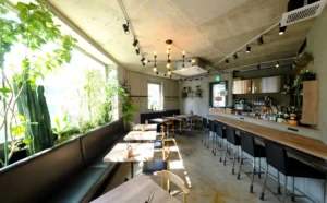 打ちっぱなしコンクリートの中にあたたかさを、木とグリーンで魅せる【Bistro 碧い月】